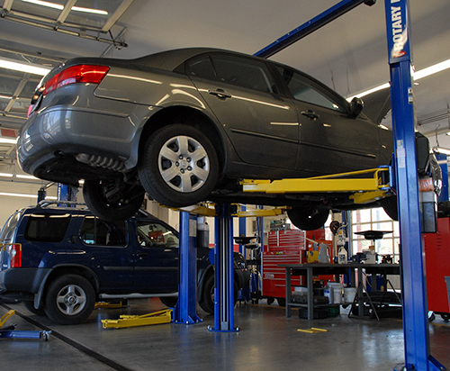 Car raised in a garage bay for wheel work